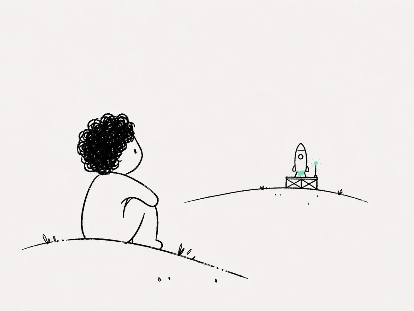 A person sitting on a hill, watching a small rocket waiting on its launch pad in the distance.